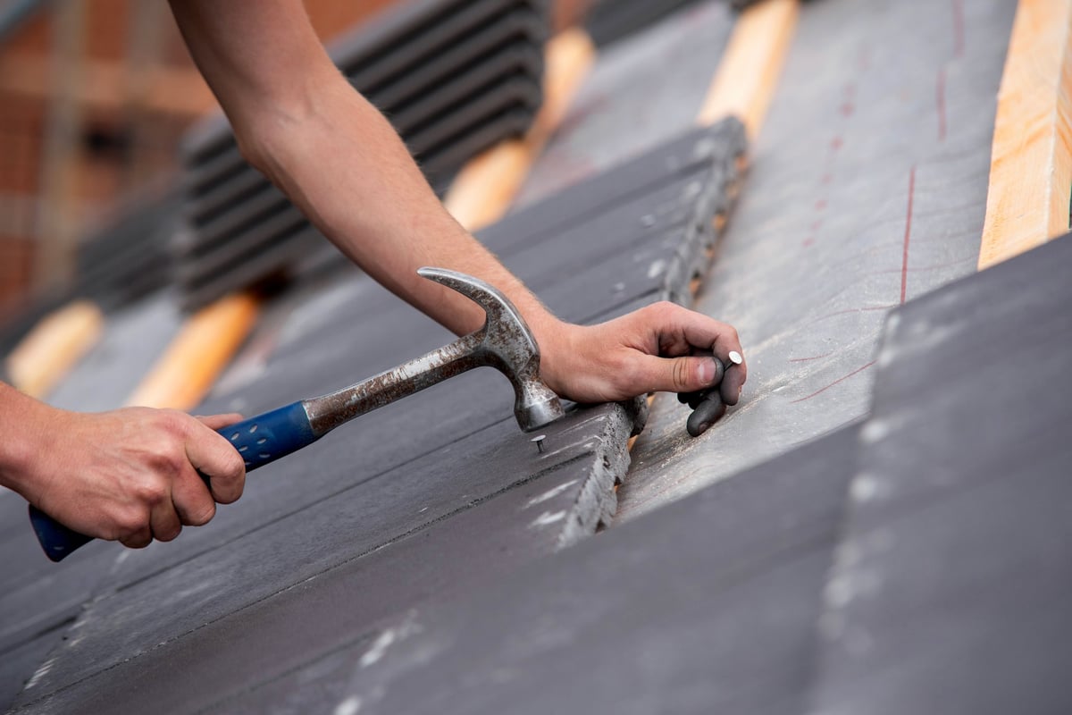 Skilled builder placing roofing tiles with care